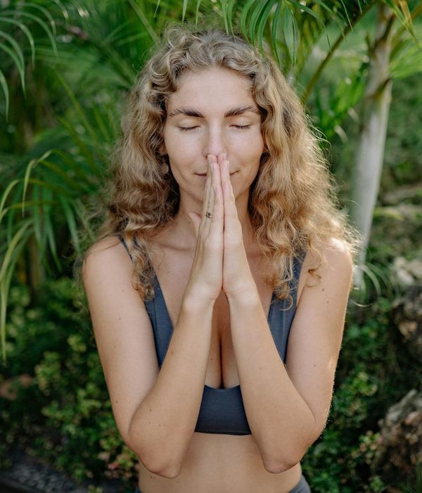 Woman practicing a restorative yoga pose in a calm dark environment.